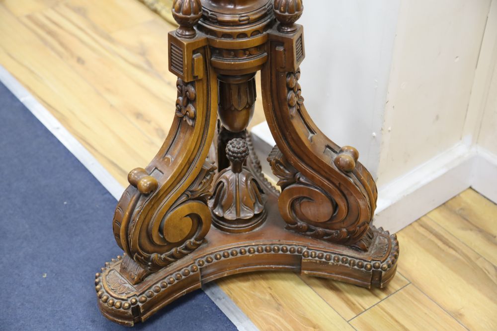 A pierced metal lantern with coloured glass panes, on carved walnut triform pedestal, 206cm overall
